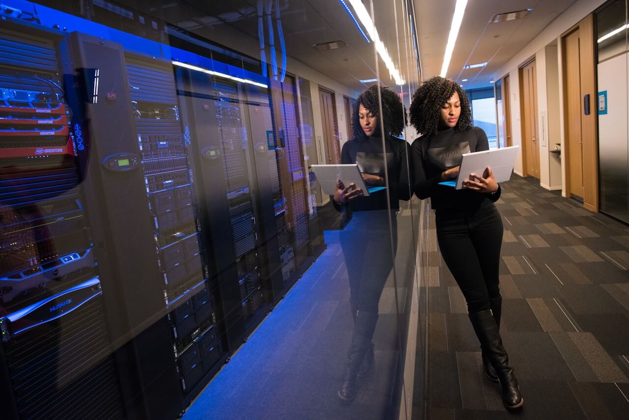 Woman with laptop working with servers